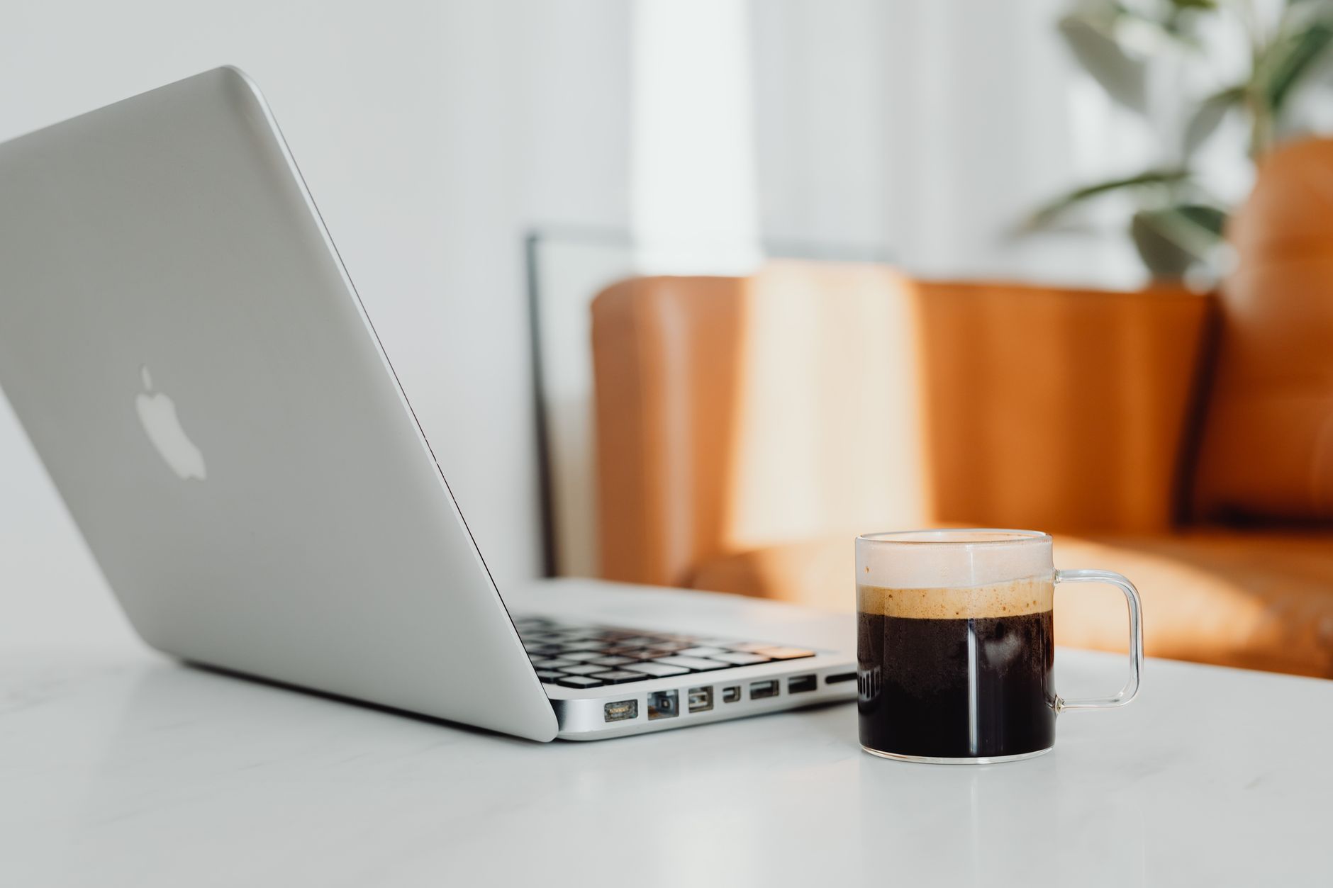 Hyggeligt stuemiljø med en bærbar computer og en kop kaffe på et skrivebord